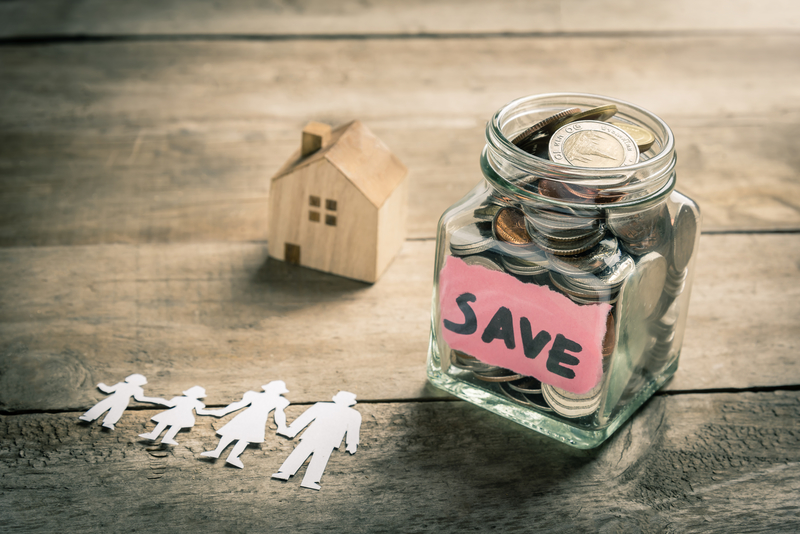Jar of coins with paper family and wooden house. Family saving money for buying house concept