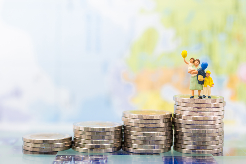 Family figure standing tall on the top of a stack of coins